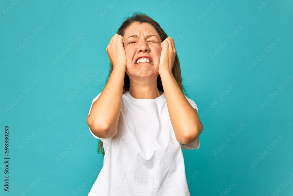 A young caucasian woman isolated crying, unhappy with something, agony and confusion concept. A young caucasian woman isolated crying, unhappy with something, agony and confusion concept.