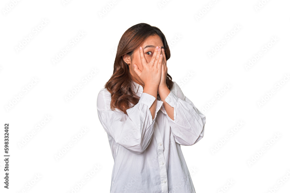 A young chinese woman blink through fingers frightened and nervous. A young chinese woman blink through fingers frightened and nervous.