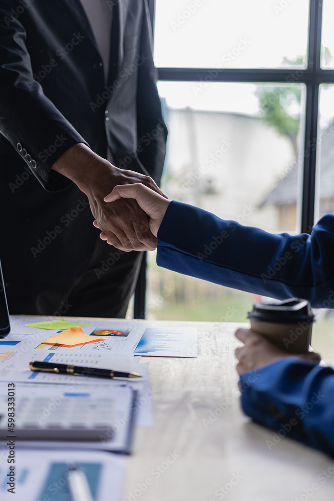 Businessmen shake hands with customers in modern conference rooms, team leaders meet with groups to greet each other. Handshakes show trust and respect on tables with documents, graphs and laptops. Po