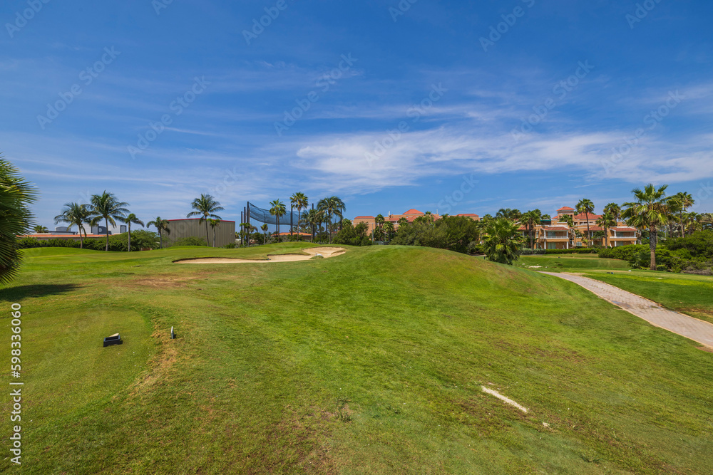 Gorgeous view of green grass golf field on background blue sky on Aruba island. Gorgeous view of green grass golf field on background blue sky on Aruba island.