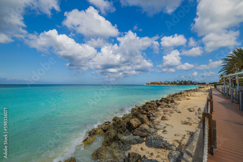 Beautiful view of walking path hotel's against backdrop of turquoise waters of Atlantic Ocean. Aruba.