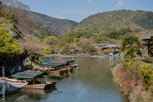 Boats in Katsura River in Arashiyama district with cherry blossom in spring time © photo3idea