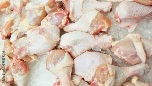 Fresh chicken thighs kept on ice cubes