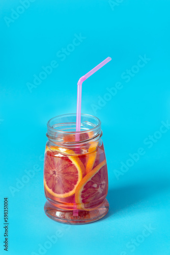 red orange lemonade in a glass jar on a blue background