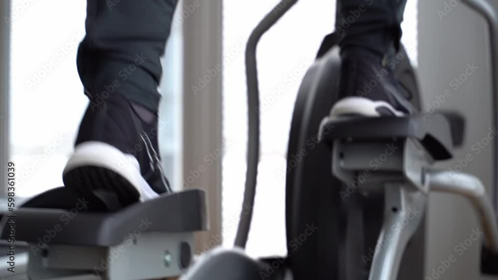 the athlete is engaged on an elliptical simulator in the gym the athlete is engaged on an elliptical simulator in the gym