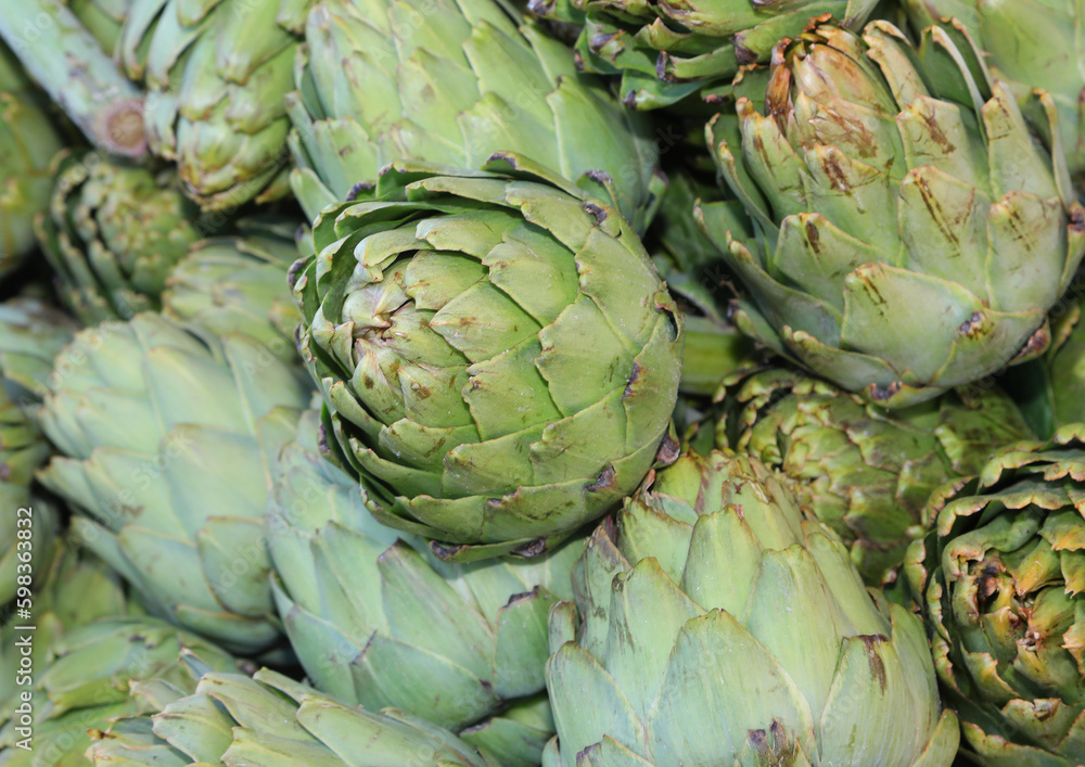 Fototapeta premium background of large ripe artichokes for sale at market