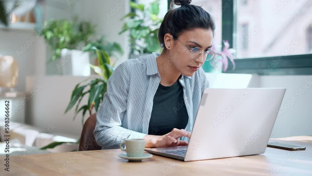 Video of beautiful attractive entrepreneur woman working with laptop while drinking coffee in the living room at home. Video of beautiful attractive entrepreneur woman working with laptop while drinking coffee in the living room at home.