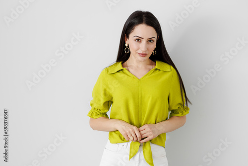 Obraz na płótnie Stunning young woman with an eye-catching lime green dress, striking a pose in front of a blank white background w salonie