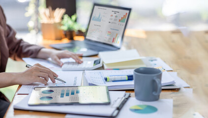Financial Businesswomen analyze the graph of the company's performance to create profits and growth, Market research reports and income statistics, Financial and Accounting concept.	