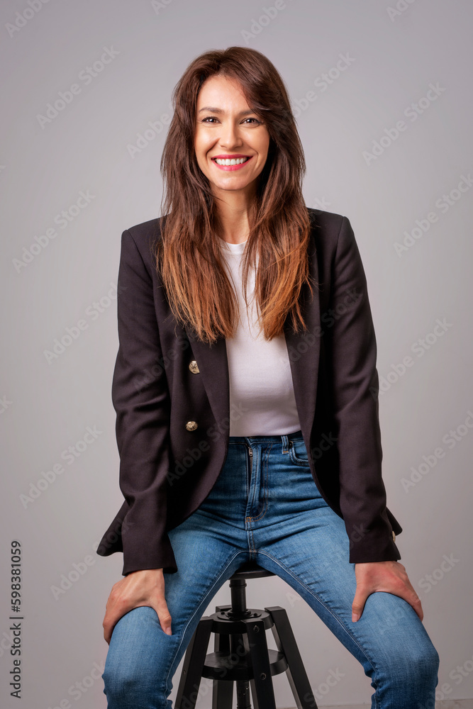 Attractive mid aged woman cheerful smiling and sitting at isolated background Attractive mid aged woman cheerful smiling and sitting at isolated background