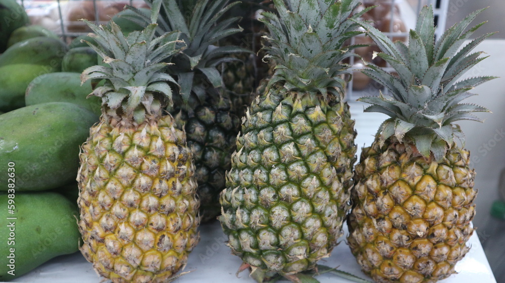 Pineapples and mangoes are sold in mini markets and placed on shelves. Pineapples and mangoes are sold in mini markets and placed on shelves.