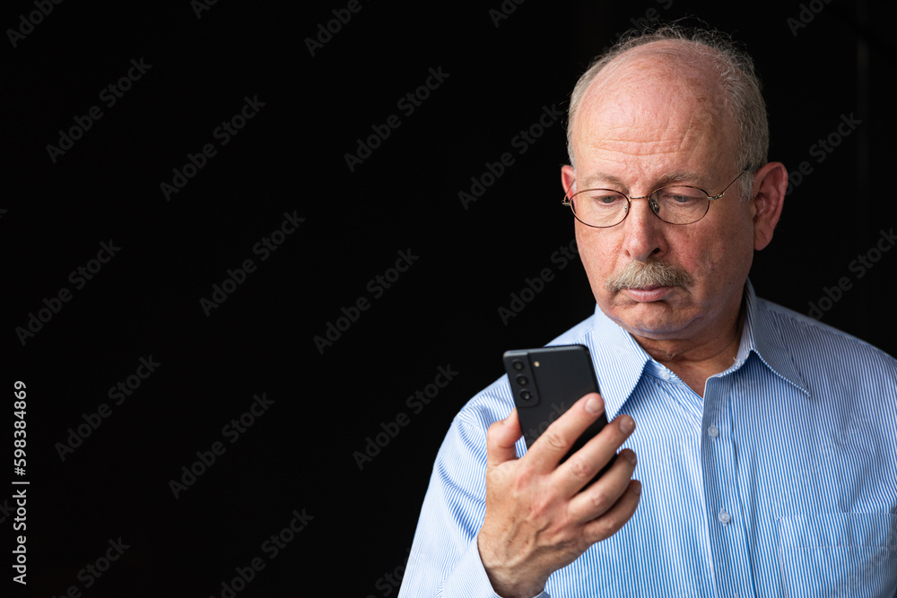 Grey haired senior man with mustache using mobile phone while texting Grey haired senior man with mustache using mobile phone while texting