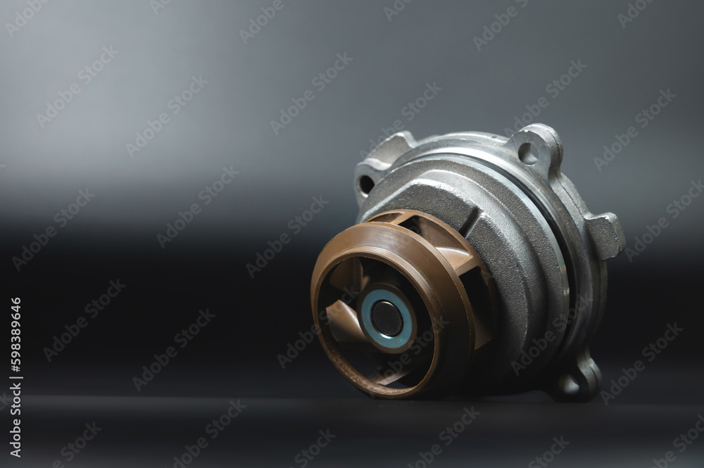 Close-up Automotive water pump, pump for pumping the coolant of the truck, part of the car engine cooling system. Black background, close-up, selective focus Close-up Automotive water pump, pump for pumping the coolant of the truck, part of the car engine cooling system. Black background, close-up, selective focus