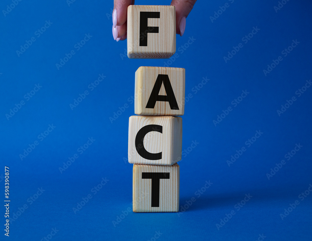 Fact symbol. Concept word Fact on wooden cubes. Businessman hand. Beautiful blue background. Business and Fact concept. Copy space. Fact symbol. Concept word Fact on wooden cubes. Businessman hand. Beautiful blue background. Business and Fact concept. Copy space.
