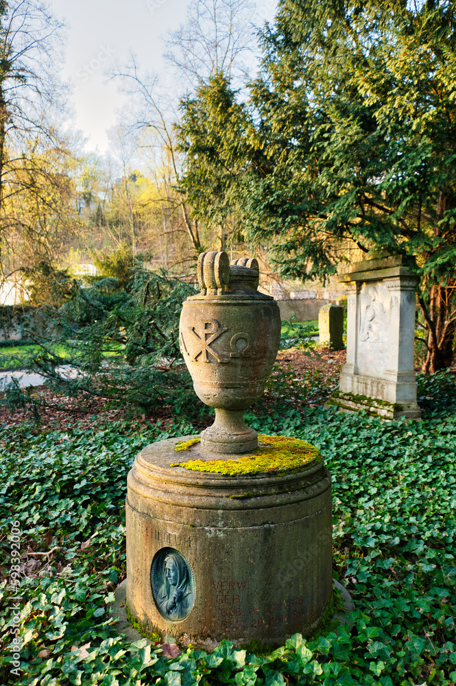 schöne alte Urne auf einem runden Grabstein auf einem Friedhof in Trier schöne alte Urne auf einem runden Grabstein auf einem Friedhof in Trier