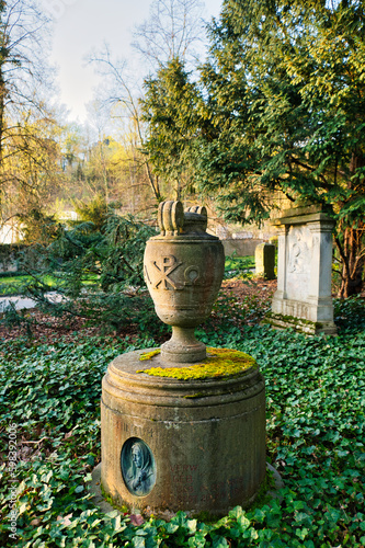 sch  ne alte Urne auf einem runden Grabstein auf einem Friedhof in Trier