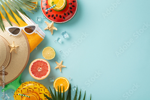 Bring on the sunshine and good times with sunglasses, cocktails, towel, hat. Top view flat lay on blue background with copyspace for text or advert