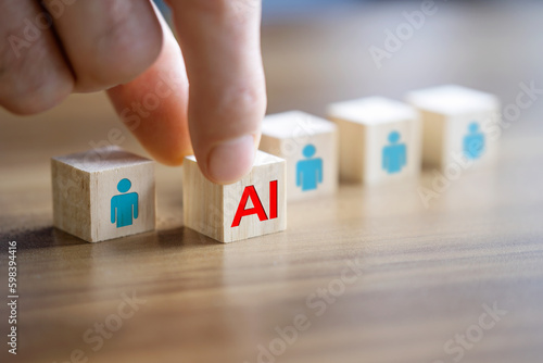 Man's hand pushes the AI written wooden cube forward. AI versus human concept.