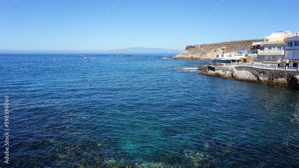 Sunny morning in La Caleta fishing village, blue ocean with transparent water, Tenerife, Canary Islands, Spain 