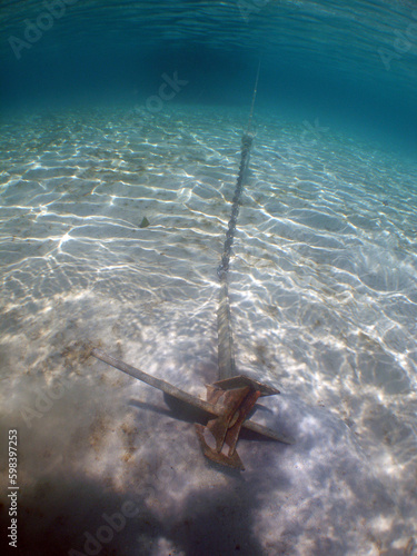 an anchor in the sand in the crystal clear waters of the caribbean sea