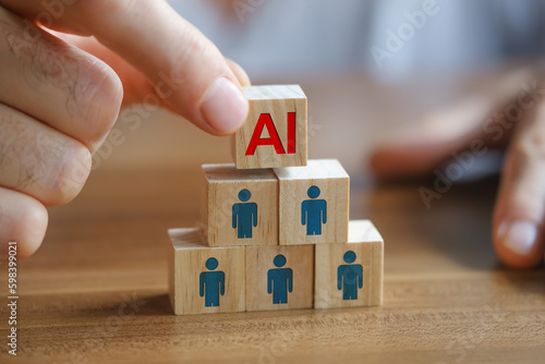 Close up shot of Man's hand putting the AI written wooden cube on top of others. Artificial Intelligence versus human concept.