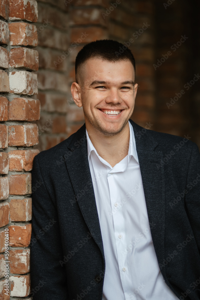 portrait of a young guy groom in a dark wool suit portrait of a young guy groom in a dark wool suit