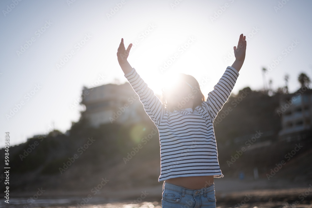 Fototapeta premium Happy girl with namaste hands on beach