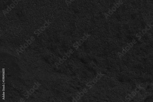 Abstract black sand texture. Dark background of black sand