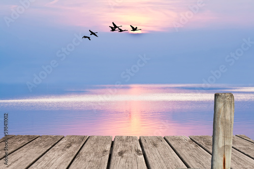paseo de madera junto al mar con el atardecer