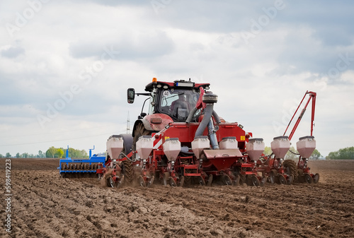 Moderne Landwirtschaft - Vorlaufwalze vorne am Traktor, Drillmaschine hinten angehängt zum Maislegen.