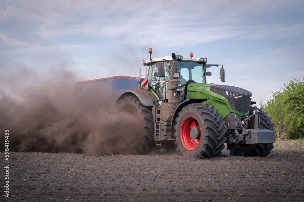 Obraz premium Trecker und Maislegemaschine verschwinden schon fast auf den Acker, so staubt es beim Maislegen.