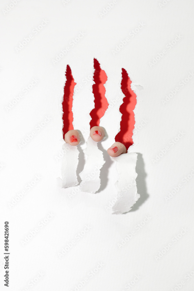 Red nails tearing the white paper from inside, showing red interior ...