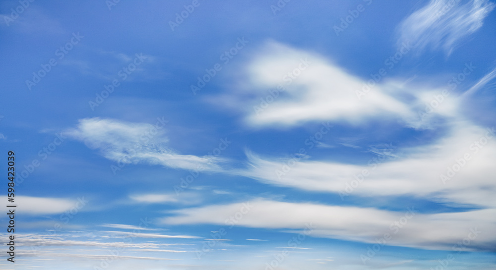 Bright blue sky background with fine cirrus clouds
