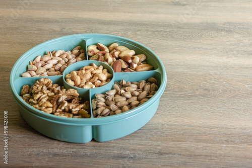 Mix of nuts in a container on a wooden table