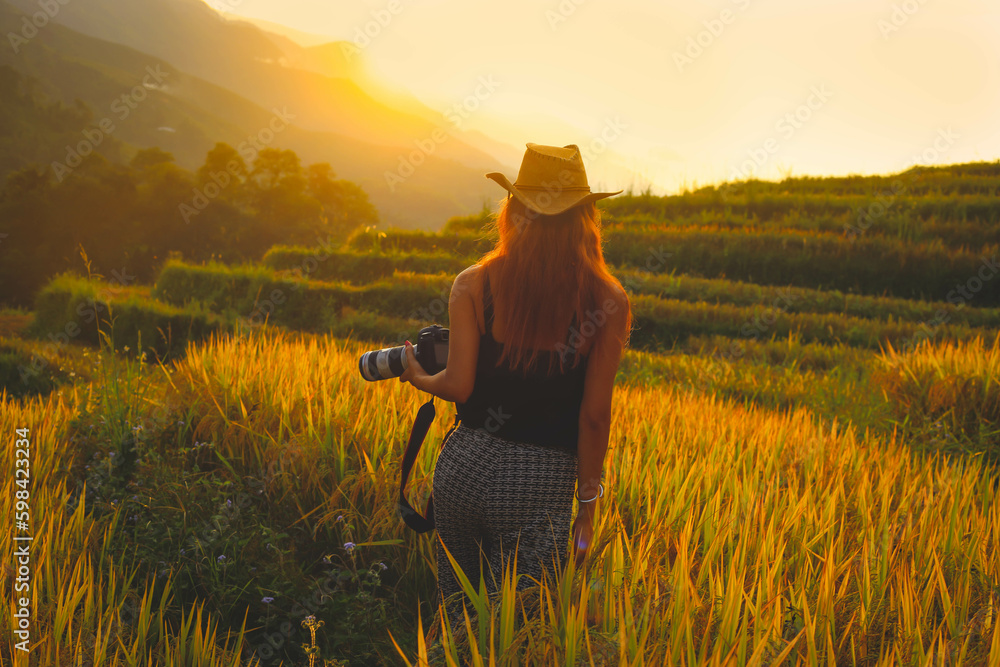 Fototapeta premium Soft focus on photographer woman taking photos with slr camera professional photography at rice terrace in Sapa, Vietnam