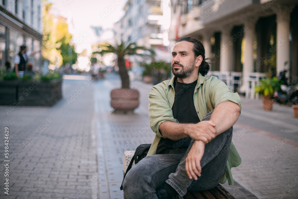 Portrait of a young man in a resort town on a bench on a small street of the old town. Portrait of a young man in a resort town on a bench on a small street of the old town.