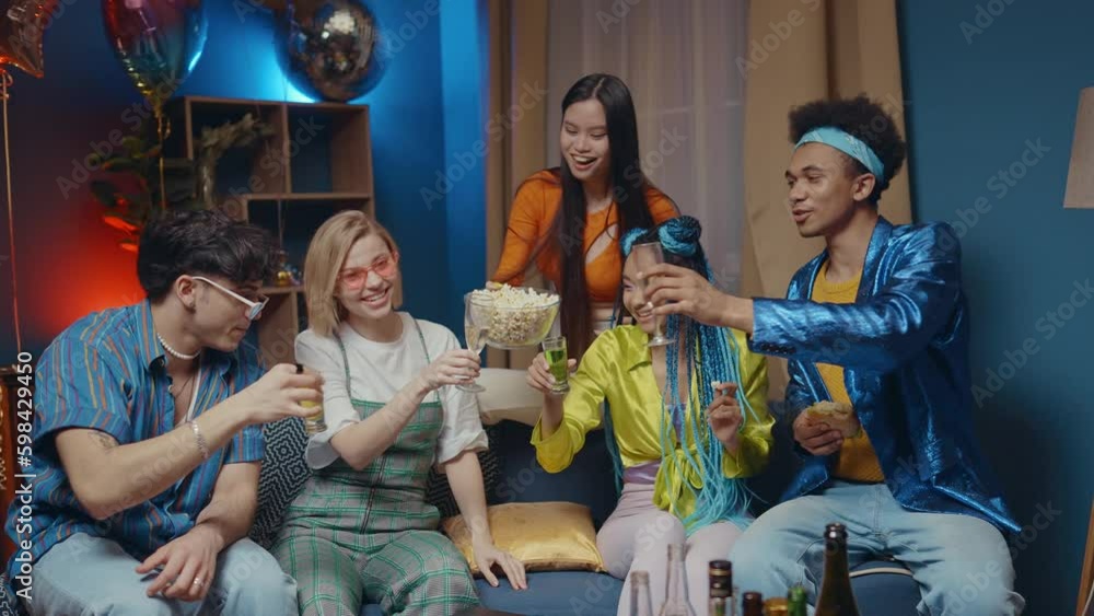 Group of friends making party at home in the living room. Multiethnic group of young people having fun in the apartment. Concept about friendship and lifestyle Group of friends making party at home in the living room. Multiethnic group of young people having fun in the apartment. Concept about friendship and lifestyle