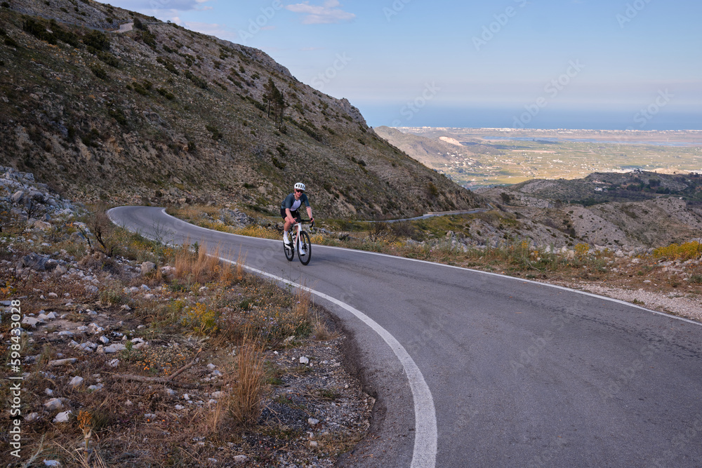 Fit male cyclist is raining for competition.Sportsmen training hard on bicycle outdoors.Sport motivation.Pego,Spain