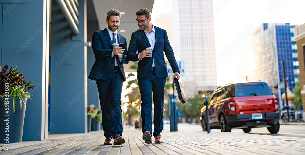 businessmen walk with phone in suit, copy space advertisement. photo of businessmen walk businessmen walk with phone in suit, copy space advertisement. photo of businessmen walk