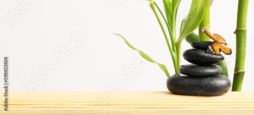 Butterfly with stones and bamboo on light background. Zen concept