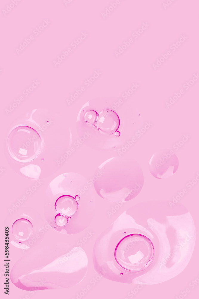 round drops of transparent gel serum on a pink background. gel with bubbles. Water droplets