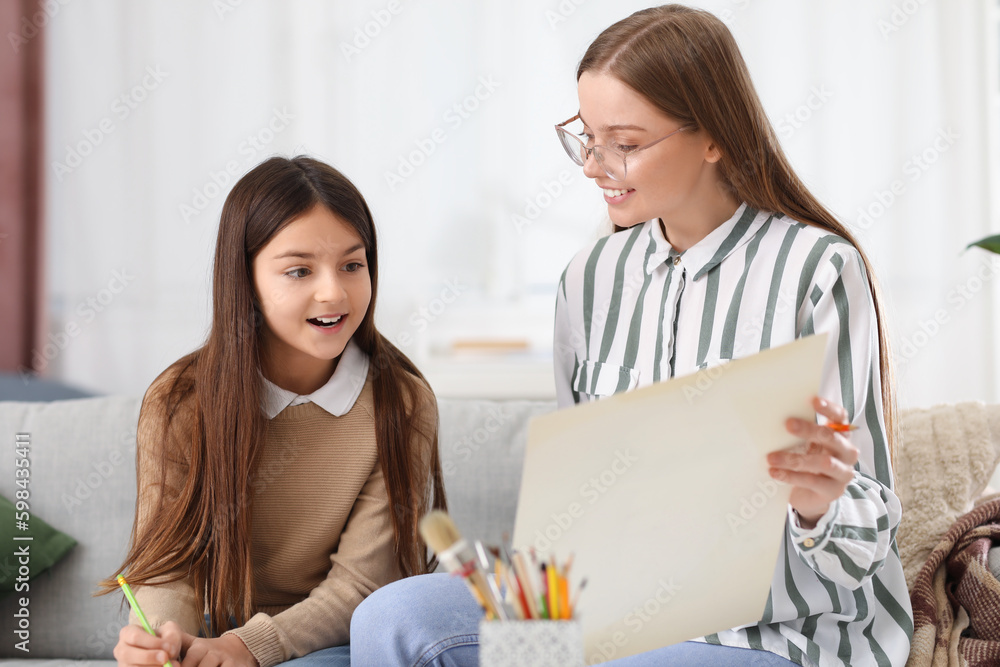 Drawing teacher giving private art lesson to little girl at home Drawing teacher giving private art lesson to little girl at home
