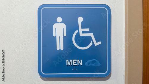 Restroom sign with figures of a girl, guy, and handicap symbol depicts gender and accessibility. The girl and guy figures indicate separate restrooms for men and women