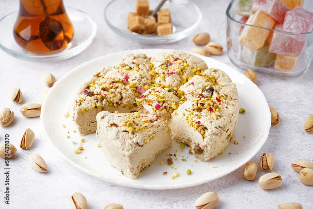 Plate of tasty Tahini halva with pistachios on light background Plate of tasty Tahini halva with pistachios on light background