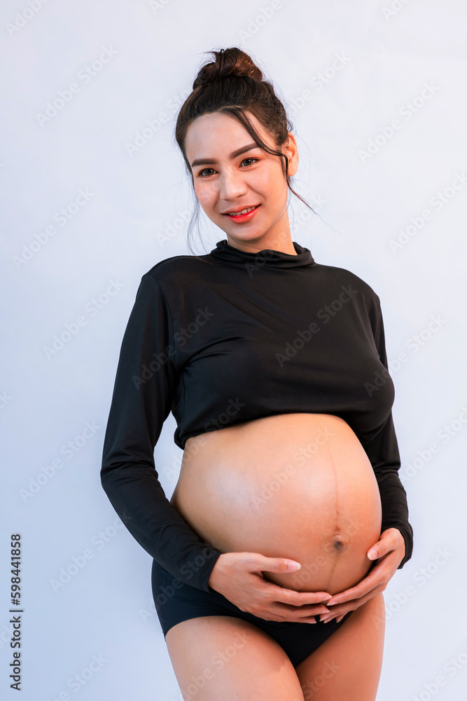 Pregnant belly. Woman standing and touching her naked big belly. a cute
