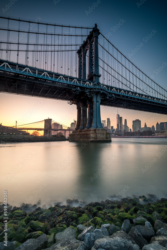 Manhattan Bridge seen from the coast next to the D.U.M.B.O area, during dusk with completely clear skies