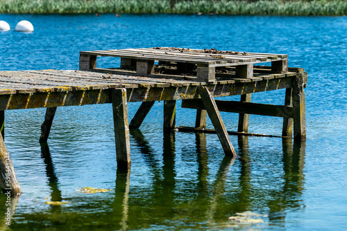Old wooden jetty on blue water