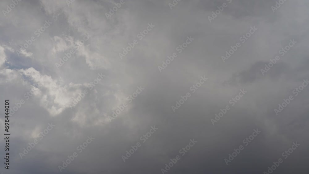 Thick clouds in sky moving at fast speed. Parts of blue sky appear in moments. Overcast and cloudy weather indicates possible precipitation time lapse Thick clouds in sky moving at fast speed. Parts of blue sky appear in moments. Overcast and cloudy weather indicates possible precipitation time lapse