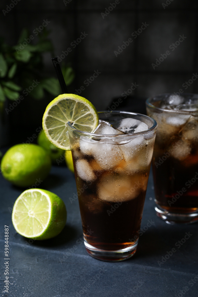 Glass of cold Cuba Libre cocktail on dark background Glass of cold Cuba Libre cocktail on dark background