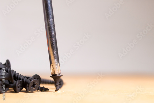 black screws on a wooden surface sorted by size